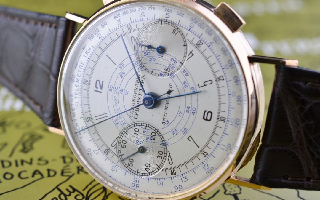 9. Silver dial, blue hands, gold case, black and blue print, central tachy